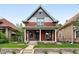 Charming brick home featuring a covered front porch with porch swing at 3008 N York St, Denver, CO 80205