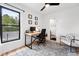 Well-lit home office space with a large window and a peek into a charming bathroom at 3008 N York St, Denver, CO 80205