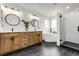 Modern bathroom featuring a wood vanity with double sinks, shiplap accent wall, soaking tub, and glass enclosed shower at 4157 Astrion Ct, Castle Rock, CO 80104