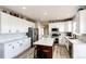 Beautiful kitchen with white cabinets, stainless steel appliances, an island with barstool seating and countertop, and hardwood flooring at 4157 Astrion Ct, Castle Rock, CO 80104