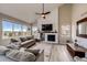 Cozy living room featuring vaulted ceilings, a fireplace with custom wood trim, and large windows with scenic outdoor views at 4157 Astrion Ct, Castle Rock, CO 80104