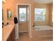 Bright bathroom featuring dual windows, tile flooring, a soaking tub, and a vanity with a sink at 6368 S Walden Way, Aurora, CO 80016