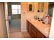 Bathroom featuring tile floor, double sink vanity with wood cabinets, and view into bedroom at 6368 S Walden Way, Aurora, CO 80016