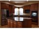 Modern kitchen with stainless steel appliances, granite countertops, central island, and ample wooden cabinetry at 6368 S Walden Way, Aurora, CO 80016