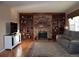 Spacious living area featuring hardwood floors, a brick fireplace, custom built-ins, and stylish decor at 6368 S Walden Way, Aurora, CO 80016