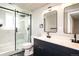 Modern bathroom with a glass-enclosed shower, black fixtures, and a double sink vanity at 10932 W 107Th Ave, Broomfield, CO 80021
