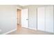 Bedroom with an open door, bi-fold closet doors, light hardwood floors and neutral paint at 10932 W 107Th Ave, Broomfield, CO 80021