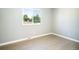 Bright bedroom featuring hardwood floors, neutral paint, and a window with a view of mature trees at 10932 W 107Th Ave, Broomfield, CO 80021
