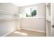 Walk-in closet with adjustable shelving, light hardwood floors, and a sunny window at 10932 W 107Th Ave, Broomfield, CO 80021
