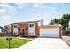 Inviting two-story brick home featuring a well-kept lawn, two-car garage, and a charming front entrance at 10932 W 107Th Ave, Broomfield, CO 80021