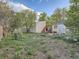 Large backyard with a storage shed, deck, and mature trees offering plenty of outdoor space at 530 S Ames St, Lakewood, CO 80226