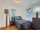 Bright bedroom with hardwood floors, two windows, and a patterned bed with dark wood furniture at 530 S Ames St, Lakewood, CO 80226