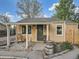 Charming home featuring an inviting covered front porch with rustic barrel planters and a comfortable rocking chair at 530 S Ames St, Lakewood, CO 80226