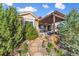 Landscaped backyard with a stone path leading to a covered patio and seating area at 6999 S Tempe Ct, Aurora, CO 80016