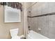 Cozy bathroom featuring a shower-tub combo with tile surround, a window, and a toilet at 6999 S Tempe Ct, Aurora, CO 80016