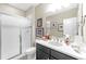 Well-lit bathroom featuring a walk-in shower, a single sink vanity, and white countertops at 6999 S Tempe Ct, Aurora, CO 80016
