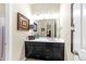Bathroom vanity with black cabinets, white countertop, decorative mirror, and stylish lighting at 6999 S Tempe Ct, Aurora, CO 80016