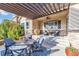 Charming covered patio with comfortable seating, ceiling fan, and beautiful blue outdoor cushions at 6999 S Tempe Ct, Aurora, CO 80016