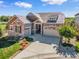 Charming home featuring stone accents, a manicured lawn, and a two-car garage at 6999 S Tempe Ct, Aurora, CO 80016