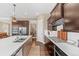 Modern kitchen with stainless steel appliances, a large island, and dark wood cabinetry at 6999 S Tempe Ct, Aurora, CO 80016