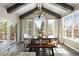 Dining room with exposed rafters, chandelier lighting, a large dining table, bench seating and beautiful window views at 7099 Cerney Cir, Castle Pines, CO 80108