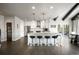 Open kitchen with island has stainless steel appliances, white cabinets, breakfast bar, and hardwood floors at 7099 Cerney Cir, Castle Pines, CO 80108