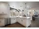 Bright kitchen with white cabinets, stainless steel appliances, island and countertops with sink and elegant pendant lighting at 7099 Cerney Cir, Castle Pines, CO 80108