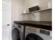 Well-equipped laundry room features modern washer and dryer, and shelving at 7099 Cerney Cir, Castle Pines, CO 80108
