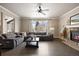 Spacious living room offers a stone fireplace, hardwood floors, large window, and comfortable gray seating at 7099 Cerney Cir, Castle Pines, CO 80108