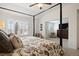 Beautiful main bedroom with 4-poster bed, sitting area, and shuttered windows at 7099 Cerney Cir, Castle Pines, CO 80108