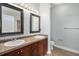 Bathroom featuring double sinks, dark cabinetry, and neutral tile flooring at 9039 E Panorama Cir # C201, Englewood, CO 80112
