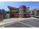 Modern multi-story building with red brick, large windows, and well-maintained landscaping at 9039 E Panorama Cir # C201, Englewood, CO 80112
