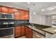 Kitchen features stainless steel appliances, granite countertops, wooden cabinets, and modern pendant lighting at 9039 E Panorama Cir # C201, Englewood, CO 80112