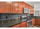 Kitchen features stainless steel appliances, granite countertops, wood cabinets, and mosaic tile backsplash at 9039 E Panorama Cir # C201, Englewood, CO 80112