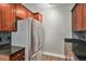 Modern kitchen features stainless steel refrigerator, granite countertops, and dark wood cabinetry at 9039 E Panorama Cir # C201, Englewood, CO 80112
