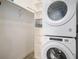 Laundry room featuring stacked washer and dryer units and storage shelves at 9039 E Panorama Cir # C201, Englewood, CO 80112