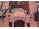 Close up exterior shot of The Hamilton building with red brick and an arched entrance at 1475 N Humboldt St # 22, Denver, CO 80218