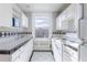 Bright kitchen with white cabinets, a double sink, and black and white tiled accents at 1475 N Humboldt St # 22, Denver, CO 80218