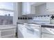 Bright kitchen featuring white cabinets, black and white tiled counters and backsplash, and large window at 1475 N Humboldt St # 22, Denver, CO 80218