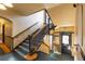 Staircase with dark wood railing, wall panelling, and carpet, showing an exit doorway at the landing at 1475 N Humboldt St # 22, Denver, CO 80218