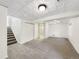 Finished basement with new carpet, white paint, tiled ceiling, and a doorway leading to a bathroom at 5005 W 128Th Pl, Broomfield, CO 80020