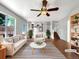 Bright living room with white walls, hardwood floors, ceiling fan, and abundant natural light at 5005 W 128Th Pl, Broomfield, CO 80020