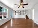 Open-concept living room with hardwood floors, large window, and access to the kitchen and staircase at 5005 W 128Th Pl, Broomfield, CO 80020
