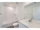 Bright bathroom featuring a bathtub with tile surround, toilet, and vanity with a quartz countertop at 15267 Fillmore St, Thornton, CO 80602