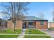 Charming brick home with a well-manicured lawn, inviting entrance, and cozy outdoor seating area at 4563 W 34Th Ave, Denver, CO 80212