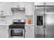 Contemporary kitchen featuring stainless steel appliances, white cabinets, and tiled backsplash at 4563 W 34Th Ave, Denver, CO 80212