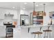 Modern kitchen with white cabinets, stainless steel appliances, and a stylish breakfast bar with seating at 4563 W 34Th Ave, Denver, CO 80212