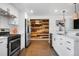 Bright kitchen featuring white cabinets, stainless steel appliances, and a unique wood accent wall at 4563 W 34Th Ave, Denver, CO 80212