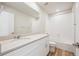 The bathroom features quartz counters, a large mirror, white vanity, tiled tub and shower, and wood-look flooring at 1417 Bloom St, Brighton, CO 80601