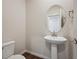 Modern powder room featuring a pedestal sink and decorative oval mirror at 1417 Bloom St, Brighton, CO 80601